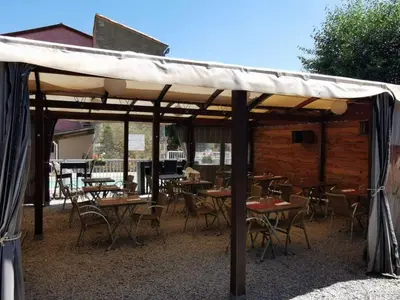 a group of tables and chairs under a pavilion at Chalet 4 pers avec terrasse à Roquefeuil - API-1-52-236 in Roquefeuil