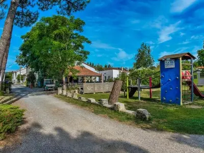 a playground with a blue building and a playground at Mobil-Home 2 Chambres avec Terrasse - API-1-52-1325 in Vielmur-sur-Agout