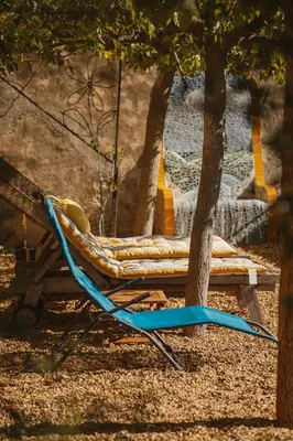 a hammock sitting under a tree next to a tree at Les Figuiers de Tamaroque in Portel-des-Corbières