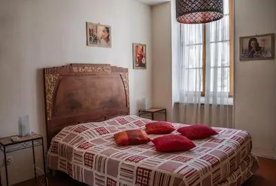 a bedroom with a bed with red pillows on it at Le Tamaroque in Portel-des-Corbières