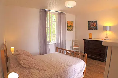 a bedroom with a bed and a dresser and a window at Chambres d'hôtes La Luciole in Tourtrol
