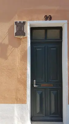 a green door on the side of a building at Gîtes Les 3 Tours in Carcassonne