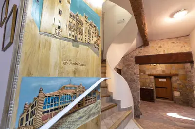 a hallway with a staircase with a picture of a building at Studio du couvent in Narbonne