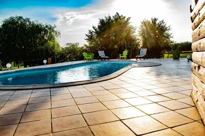 a swimming pool in a yard with chairs around it at Gîte Lempery in Puéchoursi