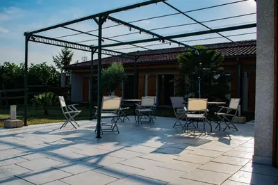 a patio with chairs and a table under a pergola at Gîte Lempery in Puéchoursi