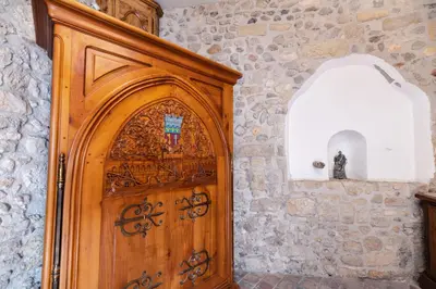 a wooden door in a room with a stone wall at Studio du couvent des carmes in Narbonne