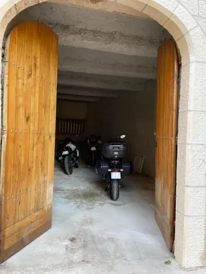 two motorcycles parked in a garage with an archway at Appartement du Couvent in Narbonne