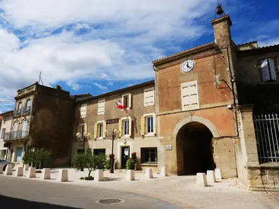an old building with a clock on the side of it at Gîte proche du canal du midi et Narbonne 2 chambres in Mirepeisset