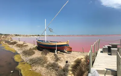 a boat sitting on the shore of a body of water at T 3 appart les jardins du phœbus in Gruissan