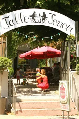 a woman holding a child under an umbrella at a restaurant at Logis Hotel - Restaurant La Marbrerie in Caunes-Minervois