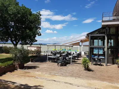 a patio with tables and chairs next to a building at Tranquil Villa with Pool in Lézignan-Corbières