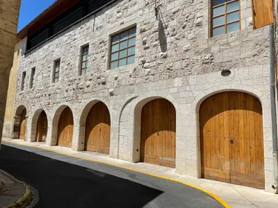 a brick building with four wooden garage doors at Chambre du Puits du Couvent in Narbonne