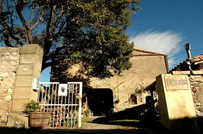 a white gate in front of a building at Gite Le Lavoir - La Poterie in Caunes-Minervois