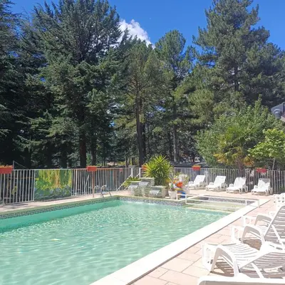a swimming pool with chairs and a fence at Camping la Source in Sournia