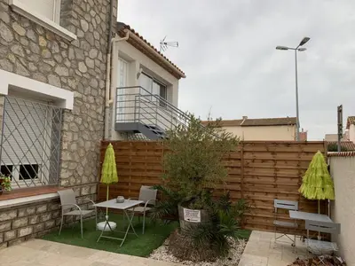 a patio with a table and chairs and a fence at La Turenne in Narbonne