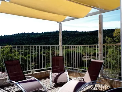 two chairs and an umbrella on a deck with a view at LA MAISON MIRAVA in La Caunette