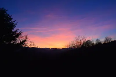 a sunset in the sky with mountains in the background at Petit Gîte TARA avec SPA - Ariege Pyrénées in Péreille