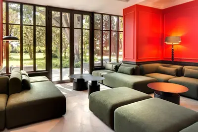 a waiting room with couches and tables and windows at Domaine de la JASSO, Demeure de grand luxe au pied de la Cité de Carcassonne, piscines et parc animalier in Carcassonne