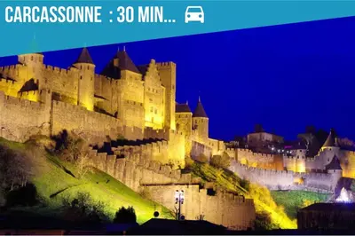 a large castle sitting on top of a hill at night at L'urbain Narbonnais in Narbonne