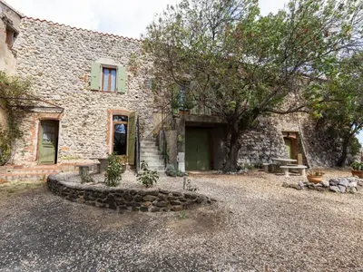 a stone building with a door and a yard at Holiday Home in Tautavel near Gorges de Gouleyrous in Tautavel