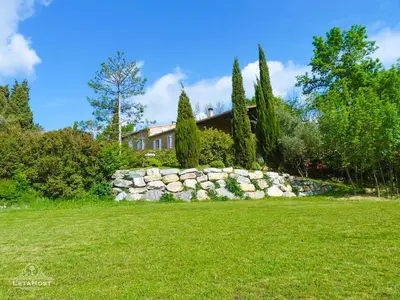 a stone wall in front of a house at Jardin Verdoyant à Soupex 