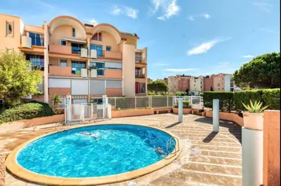 a swimming pool in front of a building at Résidence Port Soleil Duplex T3 46 m2 climatisé in Gruissan