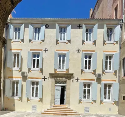 a building with blue and white windows and a door at Chambre a Baldaquin Maison de L'Église Du couvent in Narbonne