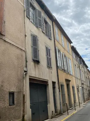 a building with a garage door on the side of a street at Le Bout du Monde Appartement Hyper-centre in Carcassonne