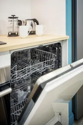a dishwasher with two cups in it in a kitchen at Superbe appartement plein centre, calme, Netflix in Mirepoix