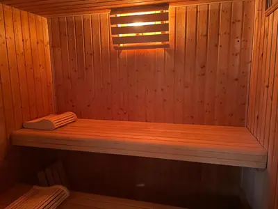 a wooden sauna with a wooden bench in it at Gîte-appart privé du Domaine Spa piscine sauna in Lescout