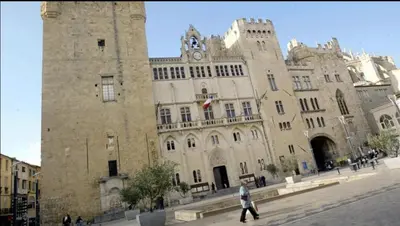 a large stone building with a clock tower at Studio au cœur du quartier historique in Narbonne