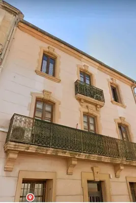 a building with a balcony on the side of it at Studio mirabeau les halles 15m2 climatisation in Narbonne