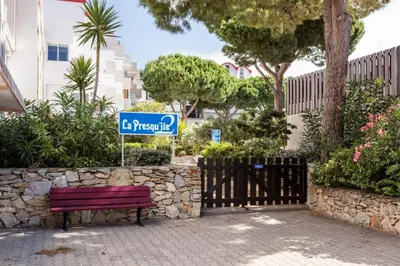 a street sign sitting next to a red park bench at Studio Gruissan La Presqu'île 2 in Gruissan
