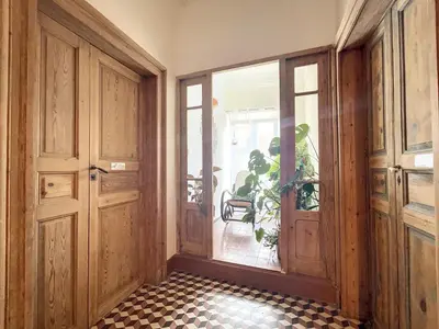 an empty hallway with doors and a tiled floor at L'oiseau Bleu FLAMANT in Roubia