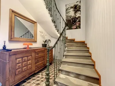 a staircase in a house with a mirror on the wall at L'Oiseau Bleu PEACOCK in Roubia