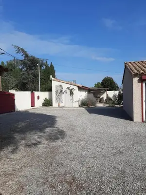 a driveway in front of a white building at Tranquillité Gite in Cuxac-dʼAude