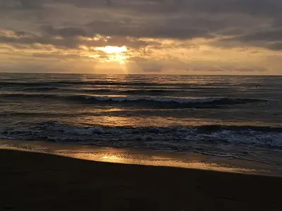 a sunset on the beach with the ocean at Le zéphyr in Gruissan