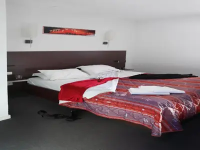 a bedroom with a bed with a red and white blanket at res La Barbacane, Carcassonne, studio for 2 people in Carcassonne