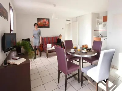 a living room with a table and purple chairs at res La Barbacane, Carcassonne, studio for 2 people in Carcassonne