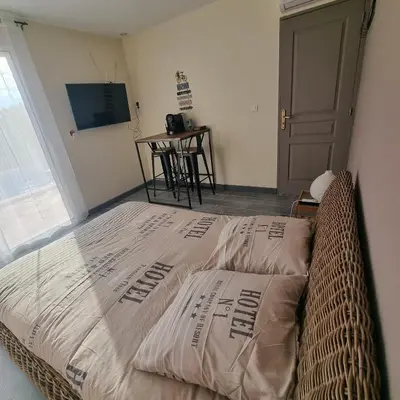 a large bed in a room with a window at Chambre avec piscine partagée in Marcorignan