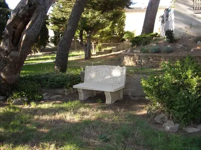 a bench sitting in the grass under a tree at Le Havre Guest room in the heart of the vineyard no2307 in Badens