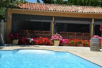 a swimming pool in front of a house with flowers at Londres guest room in the heart of the vineyard no123 in Badens