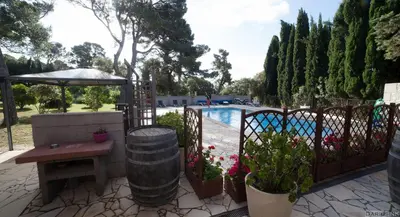 a patio with a table and a fence with a pool at Londres guest room in the heart of the vineyard no123 in Badens