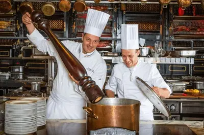 two chefs in a kitchen preparing food in a pot at L'Apothicaire Proche des Halles in Narbonne