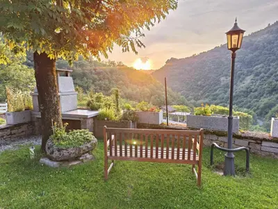 a park bench next to a tree and a street light at La Vallée in Lacrouzette