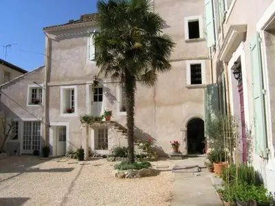 an old building with green doors and a bench in front at OCC34 - Capestang - Vigneron in Capestang
