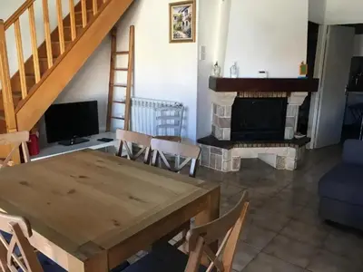 a living room with a table and a fireplace at Maison avec jardin à Sigean - Confort et tranquillité in Sigean