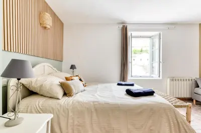 a bedroom with a large bed with a lamp on it at Au Puits de la Cité - Terrasse Vue Cité - Wifi in Carcassonne