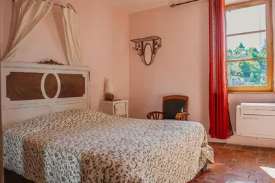 a bedroom with a bed and a window at Le Relais de Tamaroque in Portel-des-Corbières
