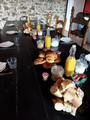 a black table with bread and bottles of orange juice at Aur Blan - Les Pipistrelles in Le Somail